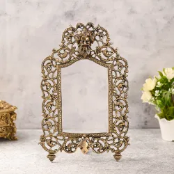 Ornate antique brass photo frame with mythological face design.
